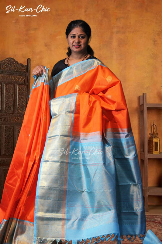 Bright orange with silver and gold zari buttas  Short and long ananda blue zari contrast border and rich zari pallu with blue border Kanchipuram Silk Saree